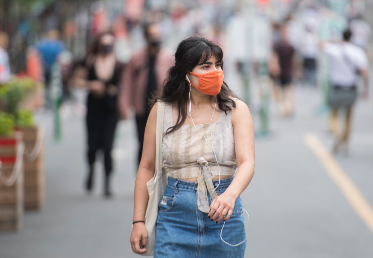 A woman wears a face mask as she walks along a street in Montreal, Saturday, June 27, 2020, as the COVID-19 pandemic continues in Canada and around the world. 