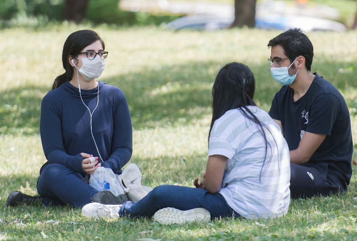 People wear face masks as they gather in a city park on Canada Day in Montreal, Wednesday, July 1 2020, as the COVID-19 pandemic continues in Canada and around the world.