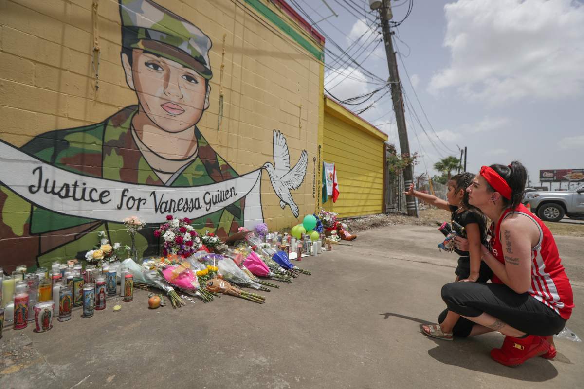 Dawn Gomez holds her 3-year-old granddaughter, Saryia Greer, who waves at Vanessa Guillen's mural painted by Alejandro "Donkeeboy" Roman Jr. on the side of Taqueria Del Sol, Thursday, July 2, 2020, in Houston.