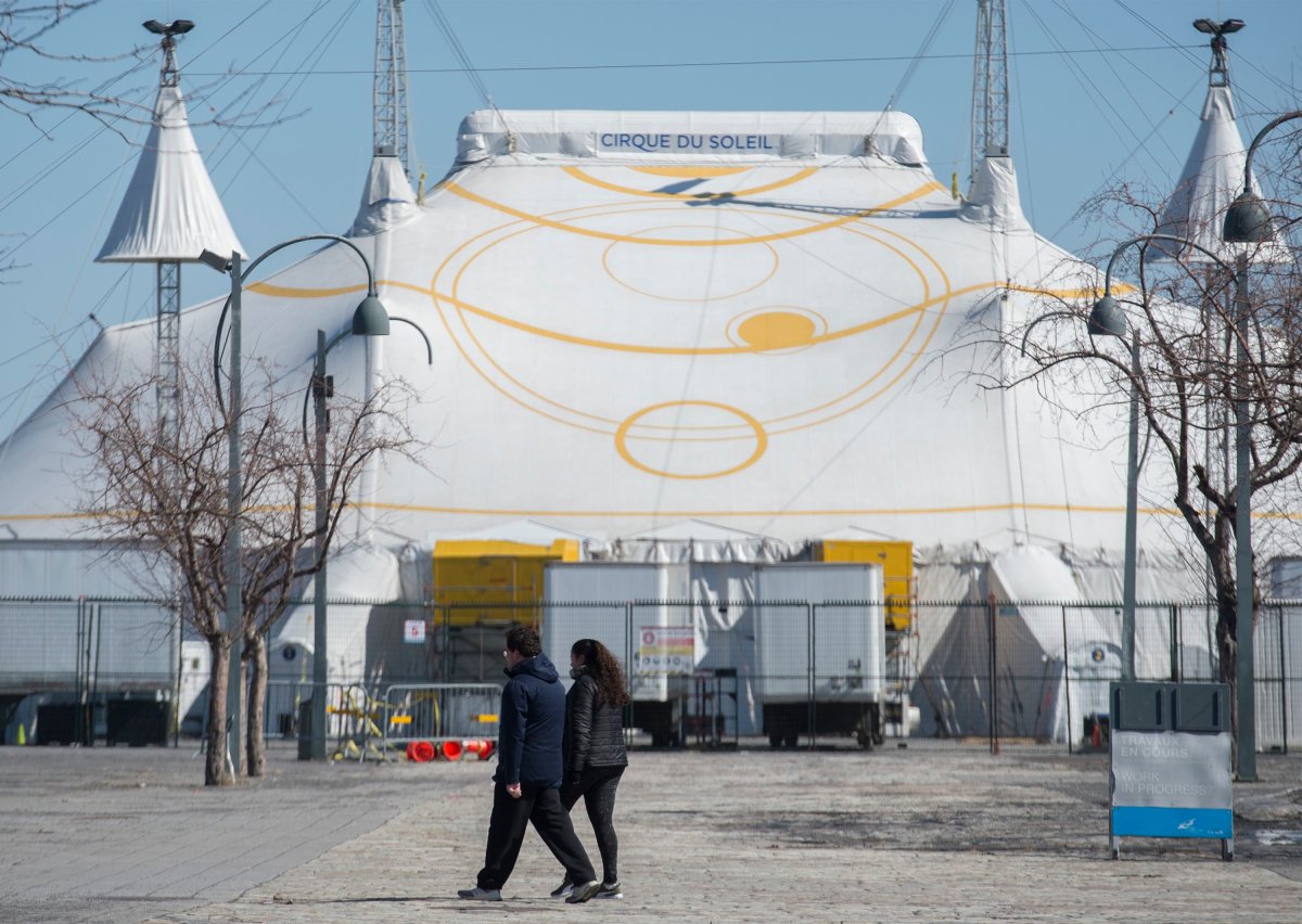 A man and woman walk by the Cirque du Soleil Big Top in Montreal's Old Port, on March 21, 2020. 