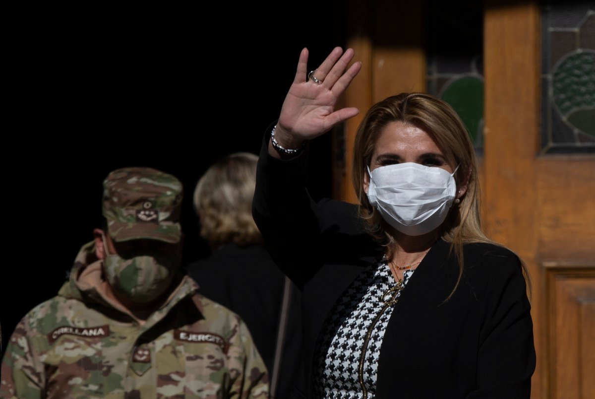 Bolivia's interim President Jeanine Anez, wearing a face mask to help curb the spread of the new coronavirus, waves during a procession Corpus Christi, in La Paz, Bolivia, Thursday, June 11, 2020.