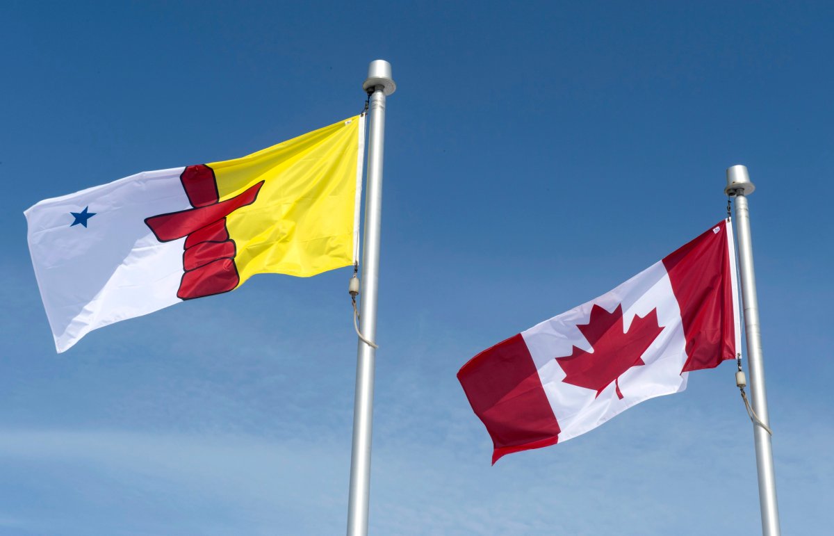 The Nunavut flag and the Canadian flag are seen Saturday, April 25, 2015 in Iqaluit, Nunavut. Tests on what would have been Nunavut's first case of COVID-19 have come back negative.  