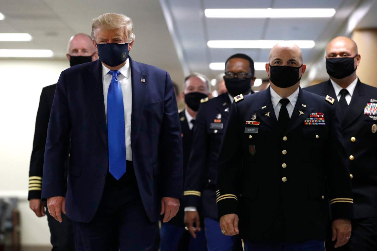 President Donald Trump wears a face mask as he walks down a hallway during a visit to Walter Reed National Military Medical Center in Bethesda, Md., Saturday, July 11, 2020.