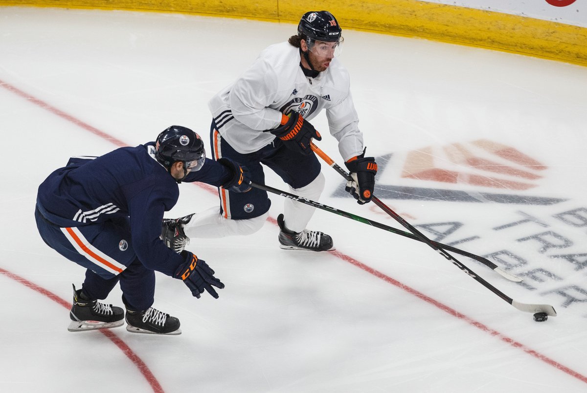 Edmonton Oilers' James Neal (18) is chased by Evan Bouchard (75) during training camp in Edmonton on Monday, July 13, 2020. THE CANADIAN PRESS/Jason Franson.