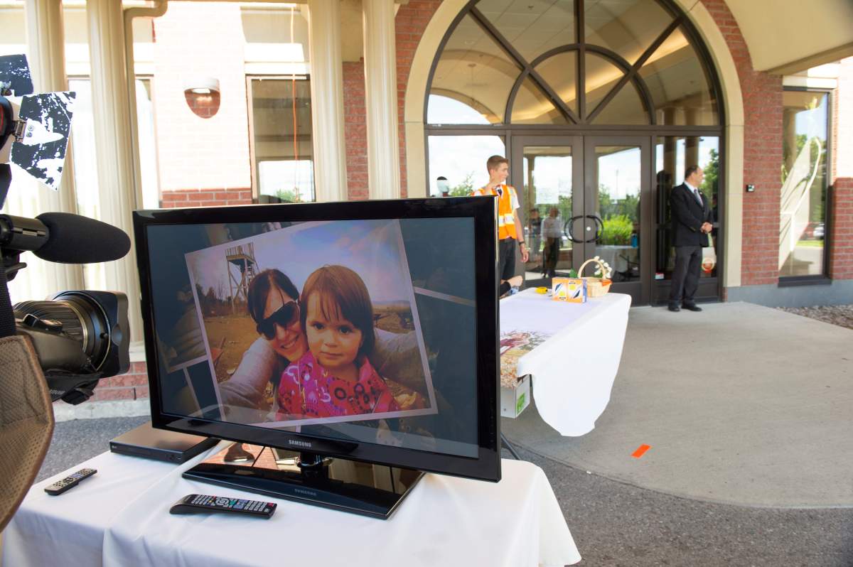 A slideshow is shown outside the funeral home in Levis, Que., where the funerals of Romy and Norah Carpentier will be held on Monday, July 20, 2020.