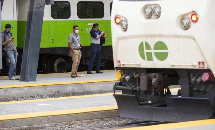 Passengers wearing face masks wait for a GO train on the platform at Union Station in Toronto on July 21, 2020.