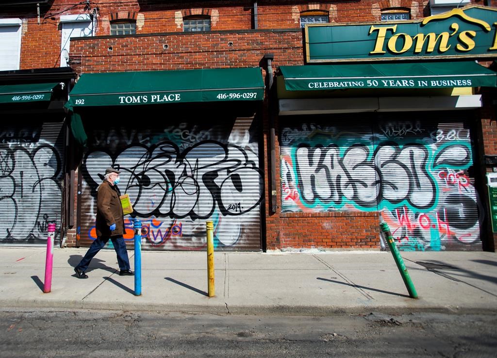 Small businesses are boarded up along an empty street in Kensington Market in Toronto amid COVID-19 lockdowns.
