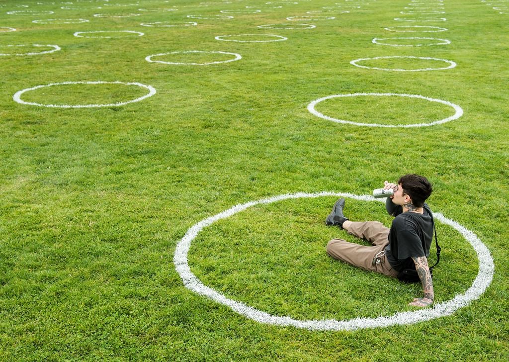 As bars, restaurants and house parties continue to play significant roles in spreading COVID-19, some infectious disease experts in Canada think it's time to offer a safer alternative to drinking in public. A man sips his beer while sitting in environmentally friendly physical distancing circles at Trinity Bellwoods Park during the COVID-19 pandemic in Toronto, Thursday, May 28, 2020. THE CANADIAN PRESS/Nathan Denette.