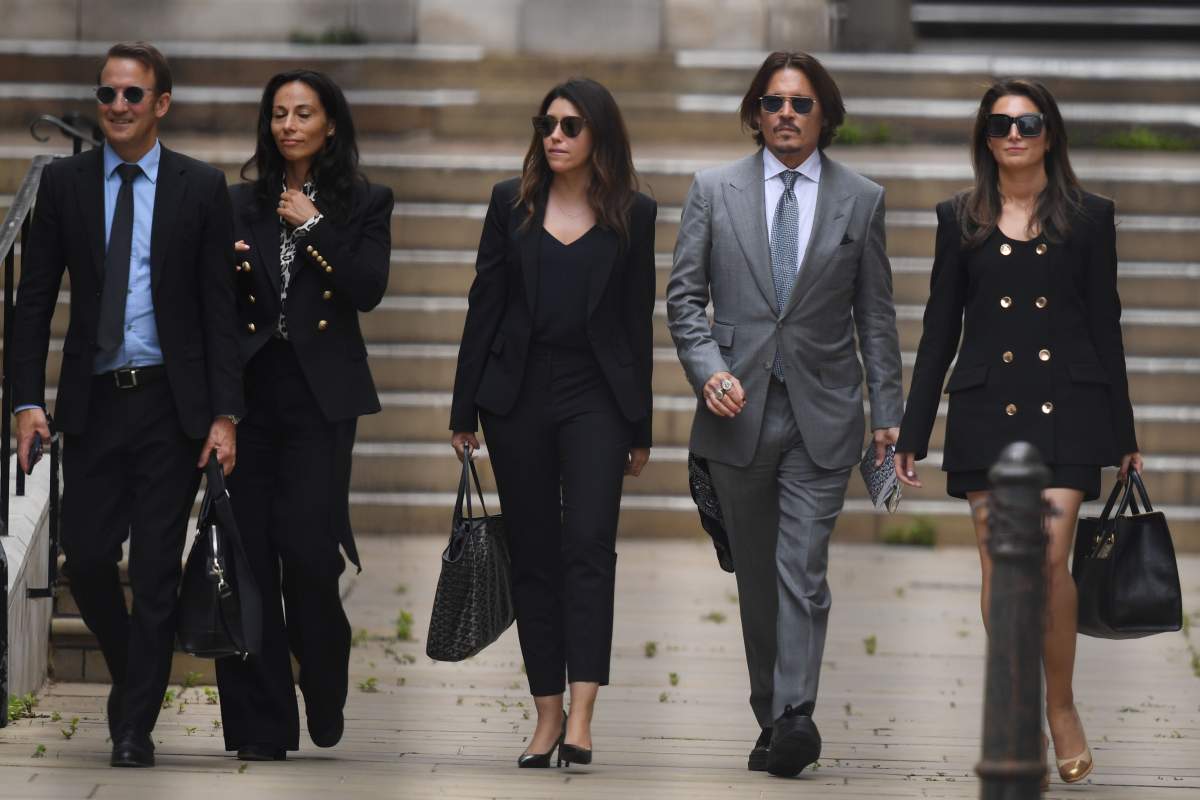 US actor Johnny Depp (2R) leaves with members of his team including lawyer Adam Waldman (L) after day eight of his libel trial against News Group Newspapers (NGN) at the High Court in London, on July 16, 2020. (Photo by DANIEL LEAL-OLIVAS / AFP) (Photo by DANIEL LEAL-OLIVAS/AFP via Getty Images)