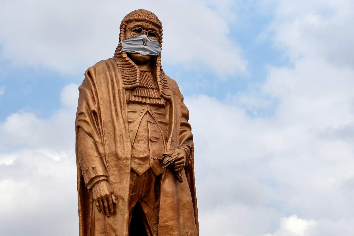 The statue of late lawyer and rights activist Gani Fawehinmi wears a face mask at the Liberty Park at Ojota in Lagos, on July 27, 2020. – The 10-metre statue to immortalise the fiery lawyer and rights advocate is being used to raise awareness about sanitary measures taken to curb the spread of the COVID-19 pandemic in Lagos, Nigeria’s commercial hub and epicentre of the virus in the country. (Photo by PIUS UTOMI EKPEI / AFP) (Photo by PIUS UTOMI EKPEI/AFP via Getty Images)