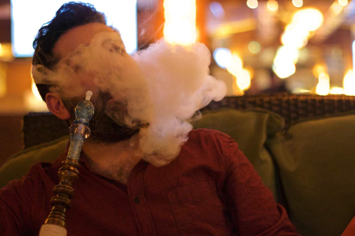 A stock image of a person smoking shisha.