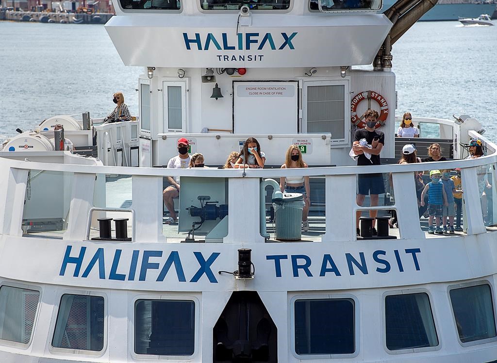 Passengers wear face masks on a Halifax Transit ferry as it arrives in Dartmouth, N.S. on Friday, July 24, 2020, the first day they have been mandatory on public transit.