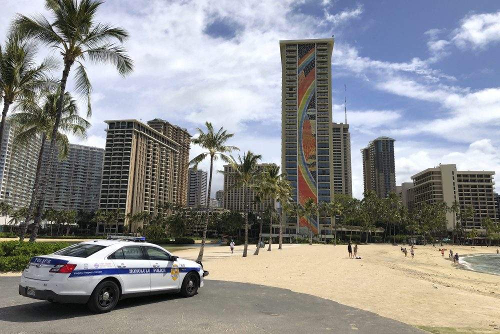 In this March 28, 2020 file photo a police officer arrives at Waikiki Beach in Honolulu.