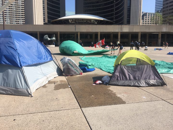 Protesters remove tents outside of Toronto City Hall on Friday.