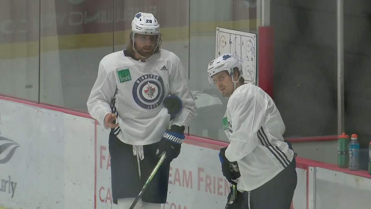 Winnipeg Jets captain Blake Wheeler talks with Mark Scheifele during a 2020 practice.