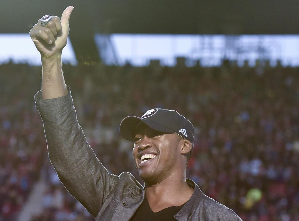 File: CFL Hall of Fame quarterback Henry Burris gives a thumbs up to the crowd during a ceremony honouring his career during the halftime of a CFL football game in Ottawa on Saturday, Sept. 9, 2017.