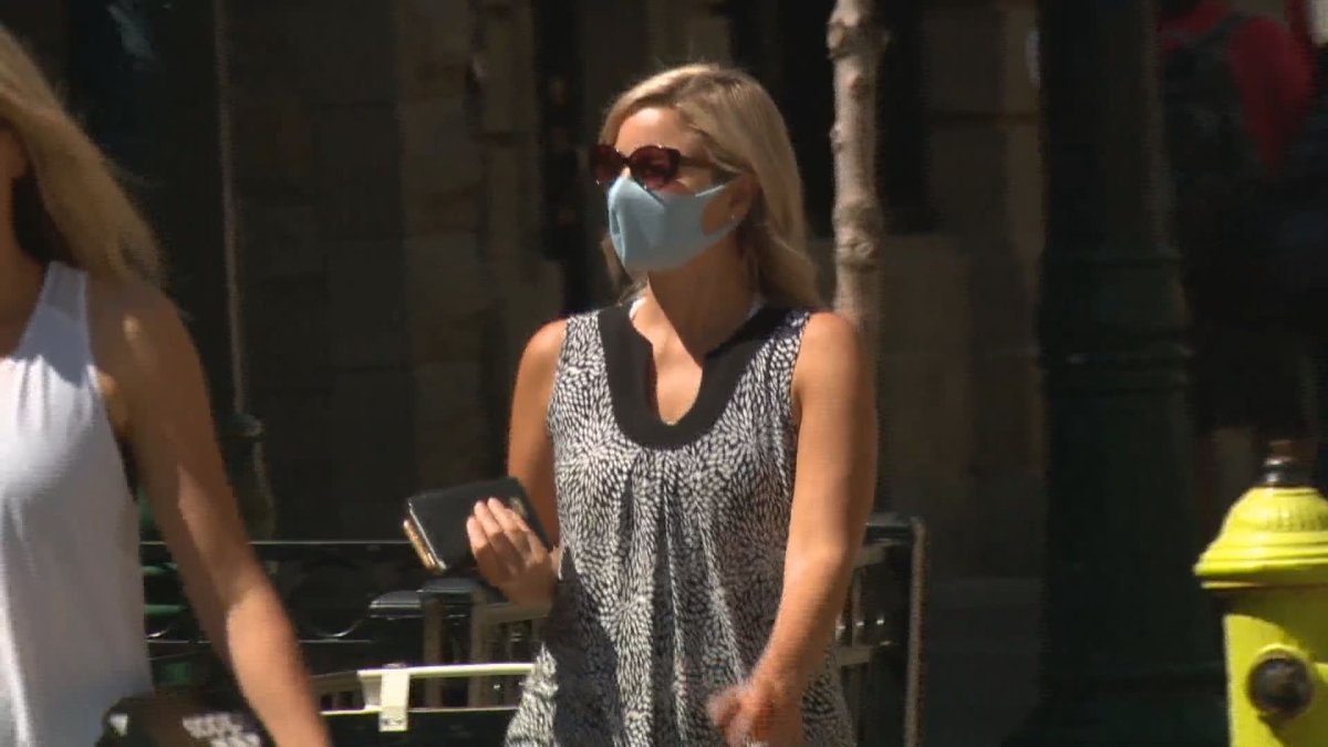 A woman wearing a face masks is seen in downtown Calgary. 
