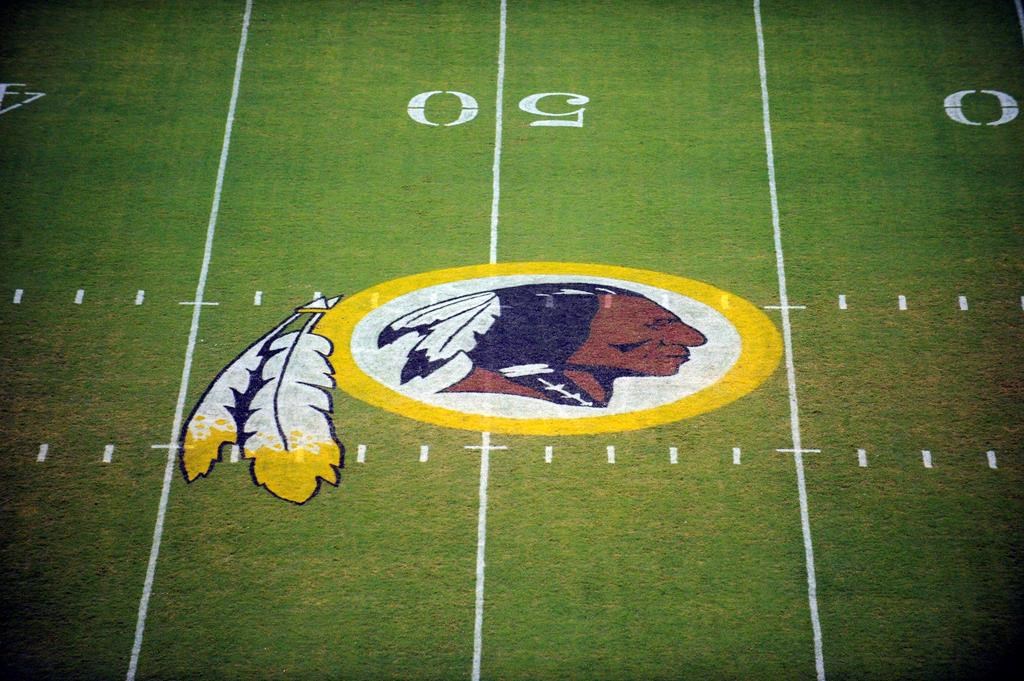 The Washington Redskins logo is shown on the field before the start of a pre-season NFL football game against the New England Patriots in Landover, Md.