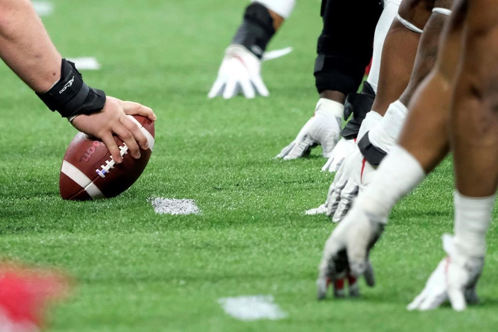A player prepares to hike the ball at the line of scrimmage during a Big Ten championship NCAA college football game in 2019 (AP Photo/AJ Mast, File).