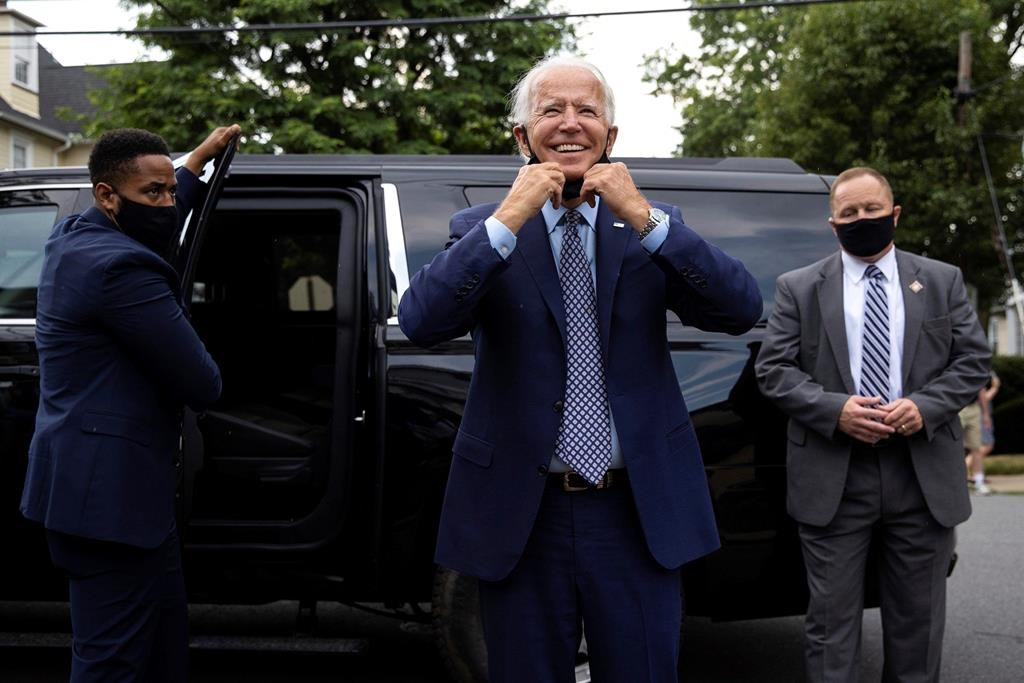 Democratic presidential candidate and former Vice President Joe Biden pulls down his mask as he makes an unannounced stop at his childhood home in Scranton, Pa., to visit the current homeowner, Anne Kearns, on July 9, 2020. (Christopher Dolan/The Times-Tribune via AP)