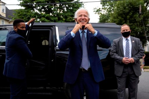 Democratic presidential candidate and former Vice President Joe Biden pulls down his mask as he makes an unannounced stop at his childhood home in Scranton, Pa., to visit the current homeowner, Anne Kearns, on July 9, 2020. (Christopher Dolan/The Times-Tribune via AP)