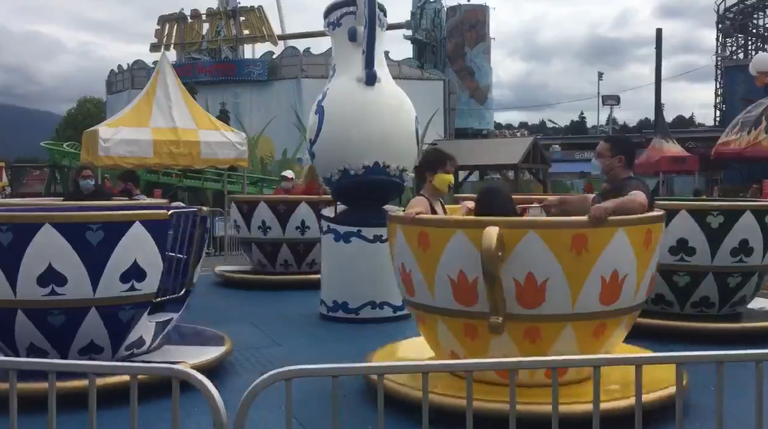 Masked visitors ride the teacups at Vancouver's Playland on July 10, 2020. 