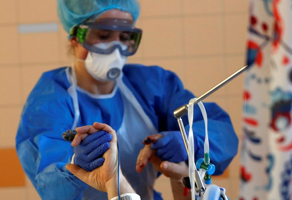 A health-care worker attends to a COVID-19 patient in an intensive care unit (ICU) at the General University Hospital in Prague, Czech Republic, Tuesday, April 7, 2020. The Centre of Excellence on Post-Traumatic Stress Disorder says health-care workers on the front lines of the COVID-19 pandemic are susceptible to severe stress that could cause long-term psychological damage. THE CANADIAN PRESS/AP/Petr David Josek.