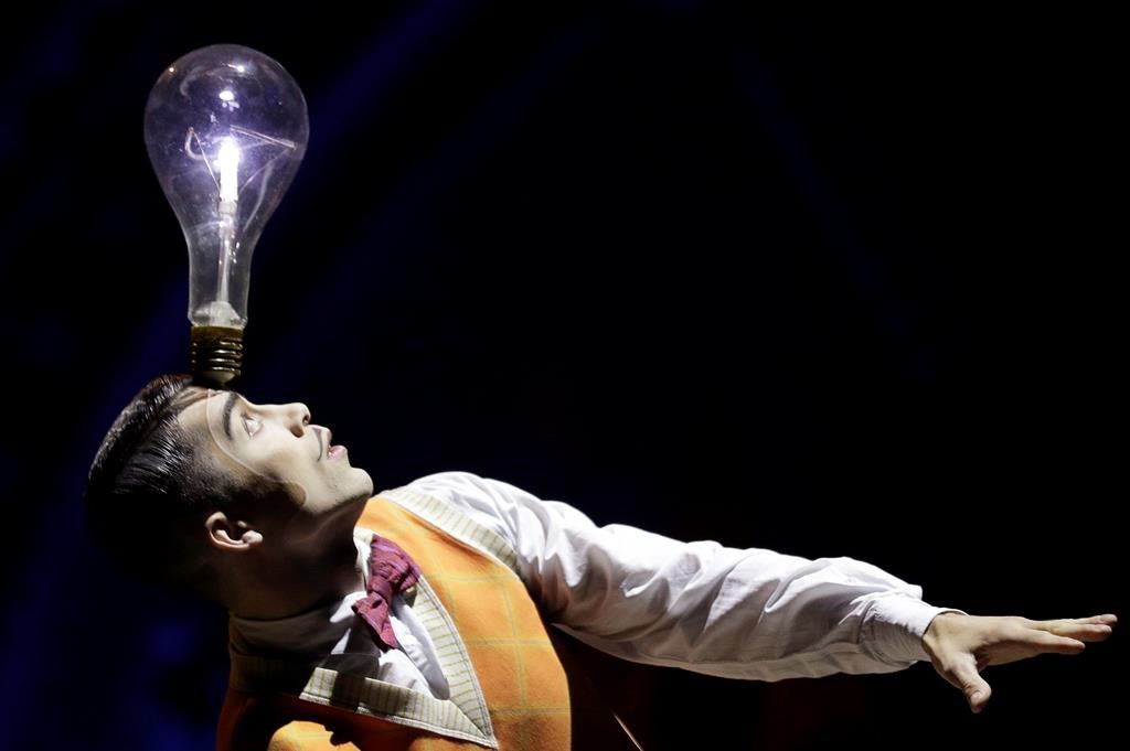 A performer balances a lightbulb on his head during a preview of the Cirque Du Soleil production of "Kurios - Cabinet of Curiosities" in Sydney, Tuesday, Oct. 1, 2019.