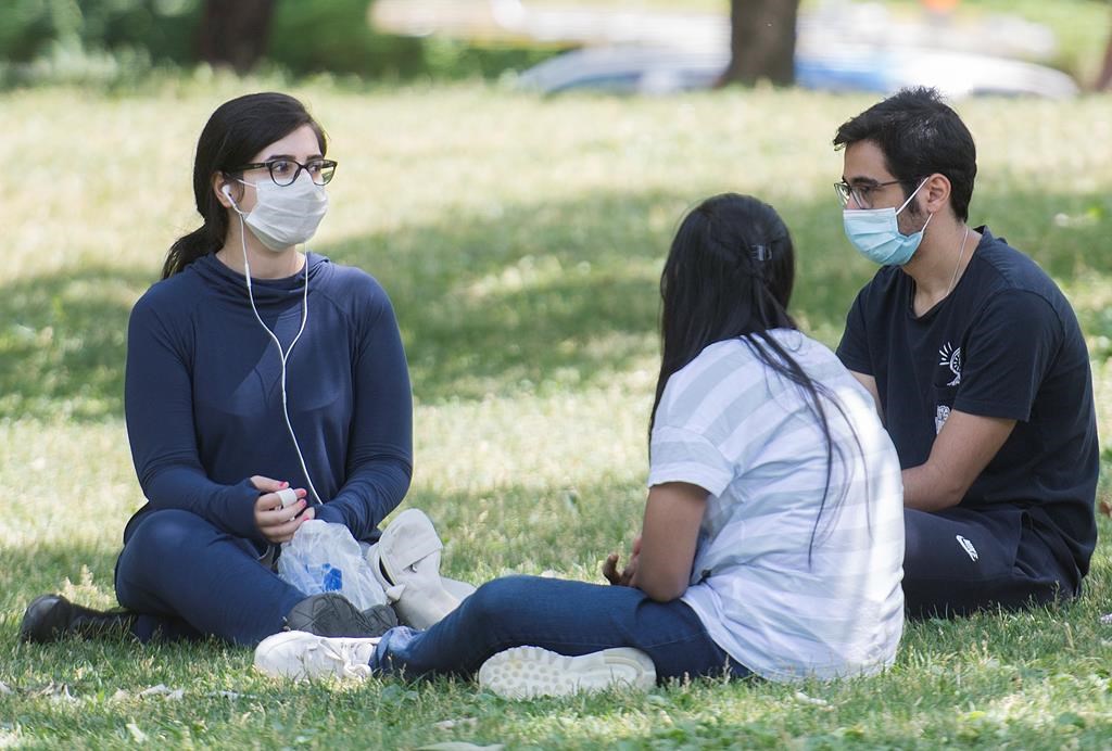 People wear face masks as they gather in a city park on Canada Day in Montreal, Wednesday, July 1 2020.
