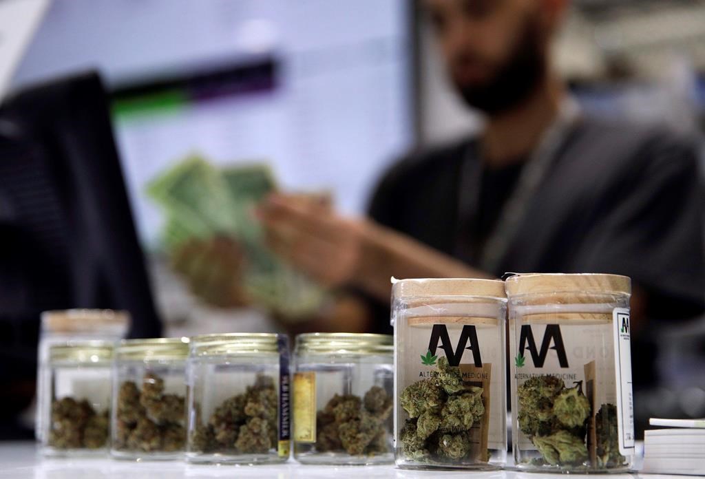 In this July 1, 2017, file photo, a cashier rings up a marijuana sale at a cannabis dispensary in Las Vegas. Ontario's private cannabis stores will have to give up offering delivery and curbside pickup next week — and they're not happy about it. THE CANADIAN PRESS/AP/John Locher.