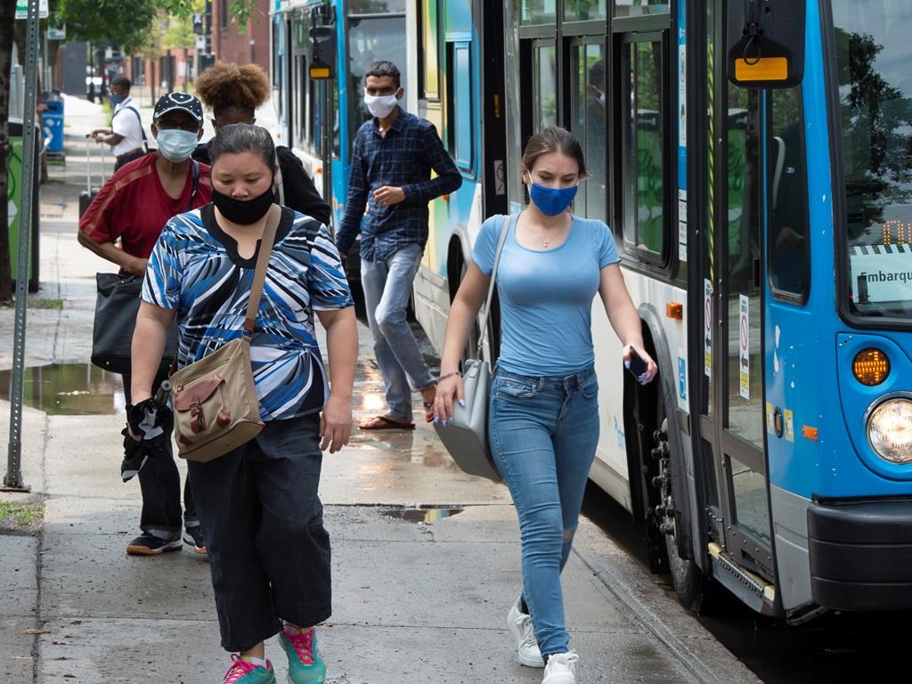 Passengers disembark from a bus, Monday, July 27, 2020 in Montreal. Quebec is reporting an additional 169 new confirmed COVID-19 cases today in addition to three deaths linked to the virus. Tuesday, July 28, 2020.