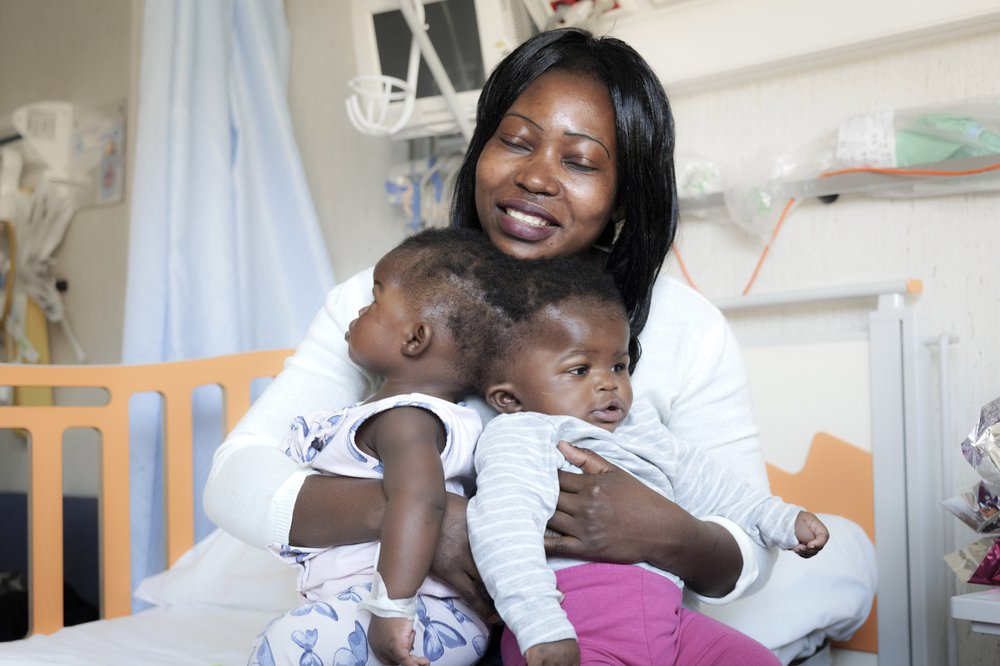 Ermine holds her conjoined twins Ervina and Prefina in this photo taken on April 2019.