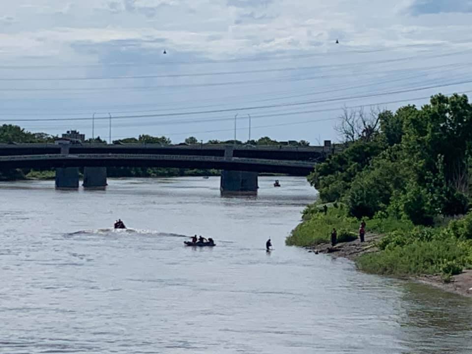 Crews search the Red River near the Louise Bridge on Friday.