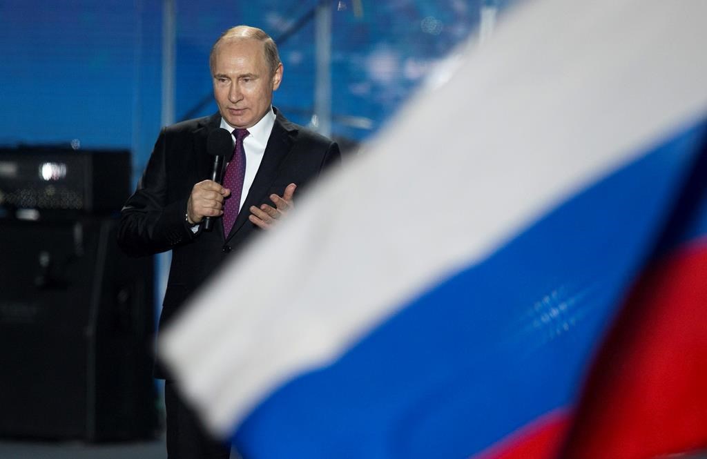 FILE - In this file photo dated Wednesday, March 14, 2018, Russian President Vladimir Putin speaks in front of a Russian National flag in Sevastopol, Crimea.