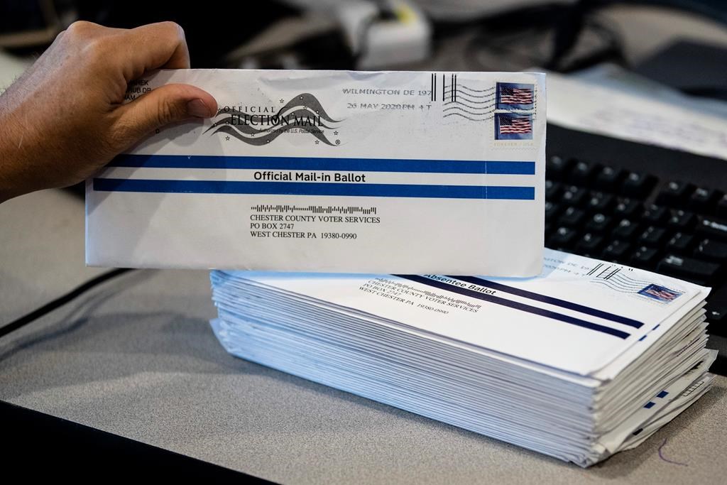 In this May 28, 2020, photo, Dave Turnier processes mail-in ballots at at the Chester County Voter Services office in West Chester, Pa., prior to the primary election. President Donald Trump’s campaign and allies have blocked efforts to expand mail-in voting, forcing an awkward confrontation with top GOP election officials promoting the opposite in their states. The rare dissonance between Trump and other Republican elected officials also reflects another reality that the president will not concede: Many in his party believe expanding mail-in voting could ultimately help him.