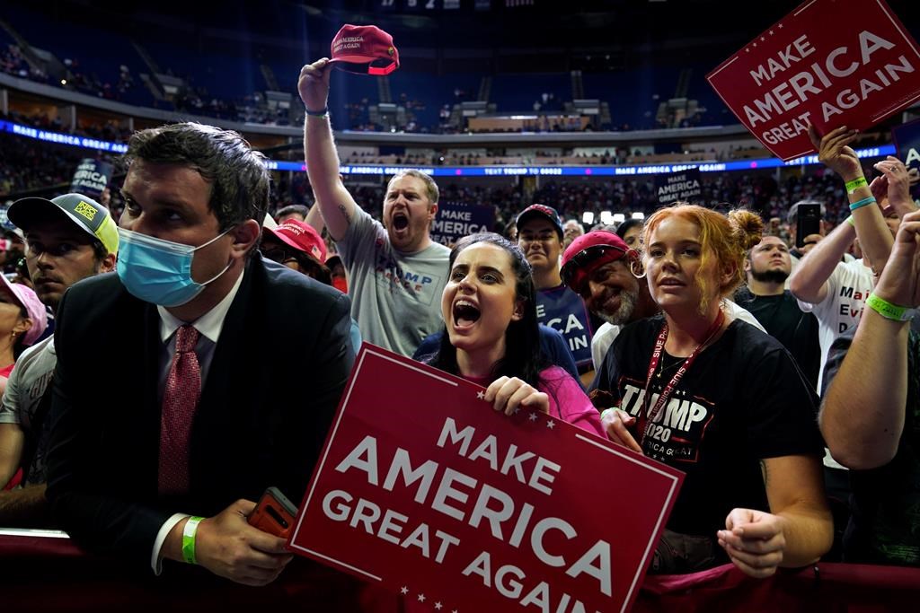 FILE - In this June 20, 2020, file photo President Donald Trump supporters cheer as they attend a campaign rally at the BOK Center in Tulsa, Okla. (AP Photo/Evan Vucci, File).