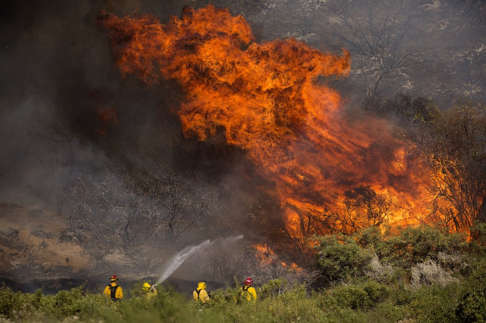 Firefighters work against the Apple Fire near Banning, Calif., Sunday, Aug. 2, 2020. 
