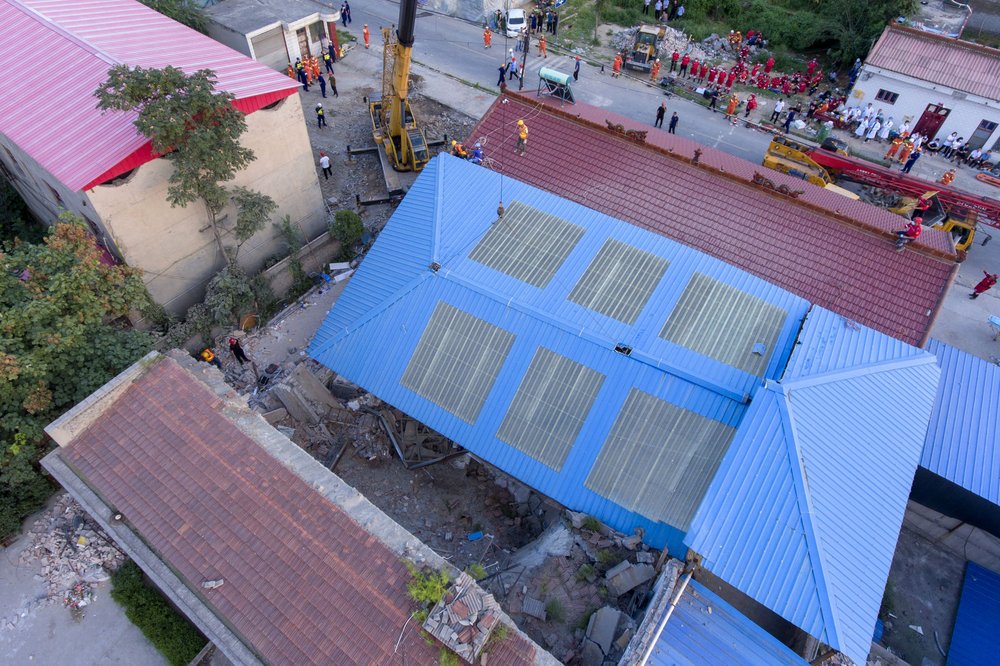 In this aerial photo released by Xinhua News Agency, rescue workers are seen near the site of a collapsed two-story restaurant in Xiangfen County of Linfen City, northern China's Shanxi Province, Saturday, Aug. 29, 2020. Rescue efforts ended at the two-story restaurant in the northern China village that collapsed during an 80th birthday celebration for a resident, leaving more than two dozen dead, authorities said Sunday. 