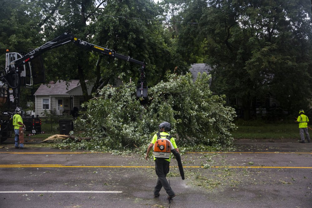 Des Moines city crews remove a tree fallen on Hickman Road, on Monday, Aug. 10, 2020, in Des Moines, Iowa after a storm with gusts more than 80 mph blew through the city.