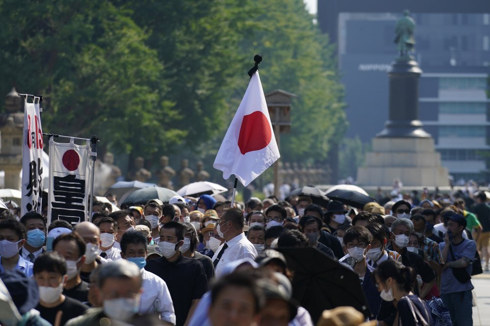 Worshippers queue to pay respects to the war dead at Yasukuni Shrine Saturday, Aug. 15, 2020, in Tokyo. Japan marked the 75th anniversary of the end of World War II.

