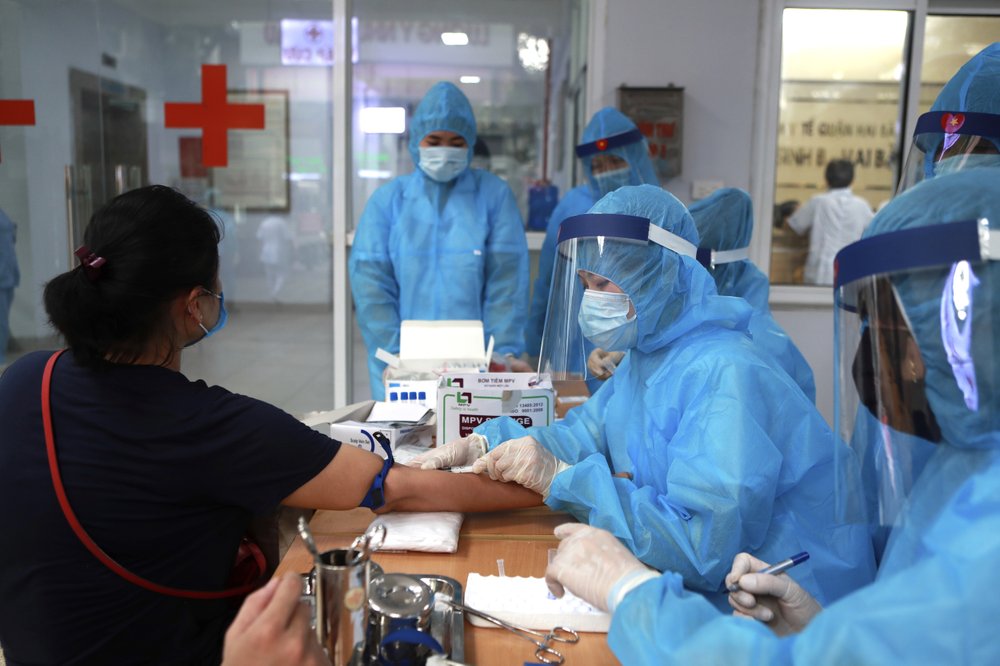A health worker draws blood for COVID-19 test in Hanoi, Vietnam on Friday, July 31, 2020. Vietnamese state media on Friday reported the country's first-ever death of a person with the coronavirus as it struggles with a renewed outbreak after 99 days without any cases. 