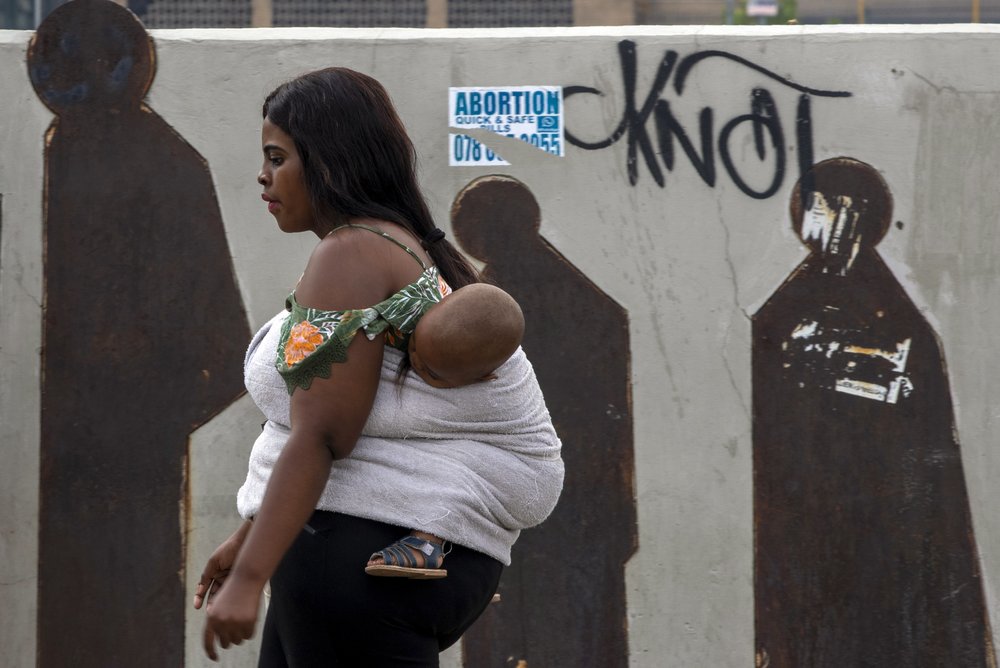 People walk along a downtown street in Johannesburg, South Africa, Monday, March 16, 2020. Millions of women and girls globally have lost access to contraceptives, abortion services and related care because of the coronavirus pandemic. Now the first widespread measure of the toll says India with its abrupt, months-long lockdown has been hit especially hard. 