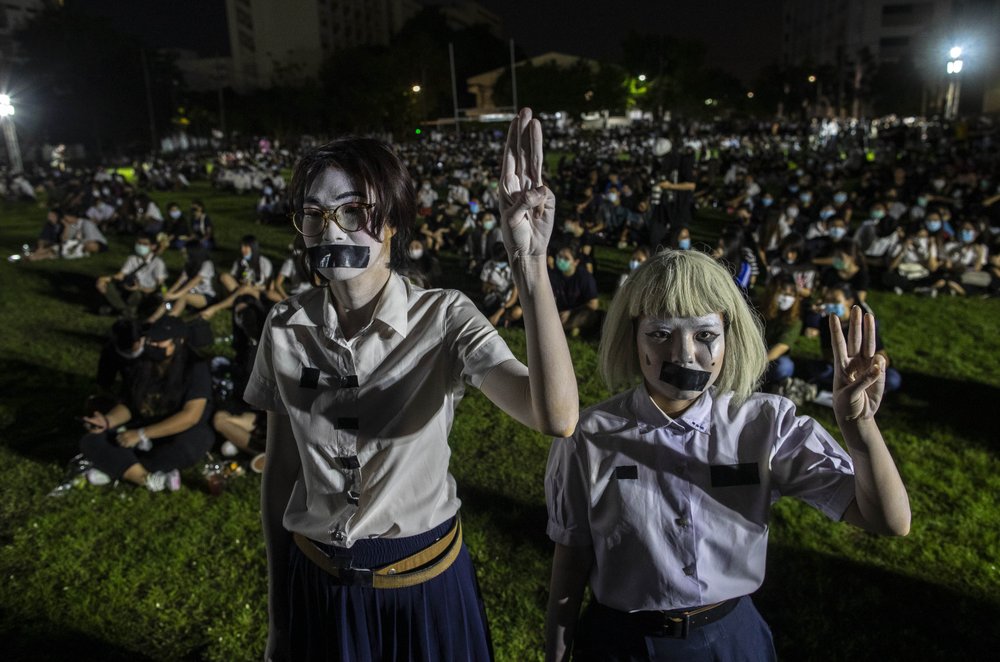 Pro-democracy students with tape covering their mouths raise a three-finger salute, a symbol of resistance, during a protest rally at Mahidol University in Nakhan Pathom, Thailand, Tuesday, Aug. 18, 2020. Student protesters have stepped up pressure on the government with three core demands: holding new elections, amending the constitution and ending the intimidation of critics of the government. 
