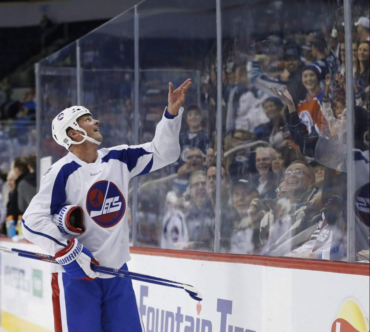 Former Winnipeg Jet Dale Hawerchuk tosses a puck to the crowd during a practice for the NHL’s Heritage Classic Alumni game in Winnipeg on Friday, October 21, 2016.