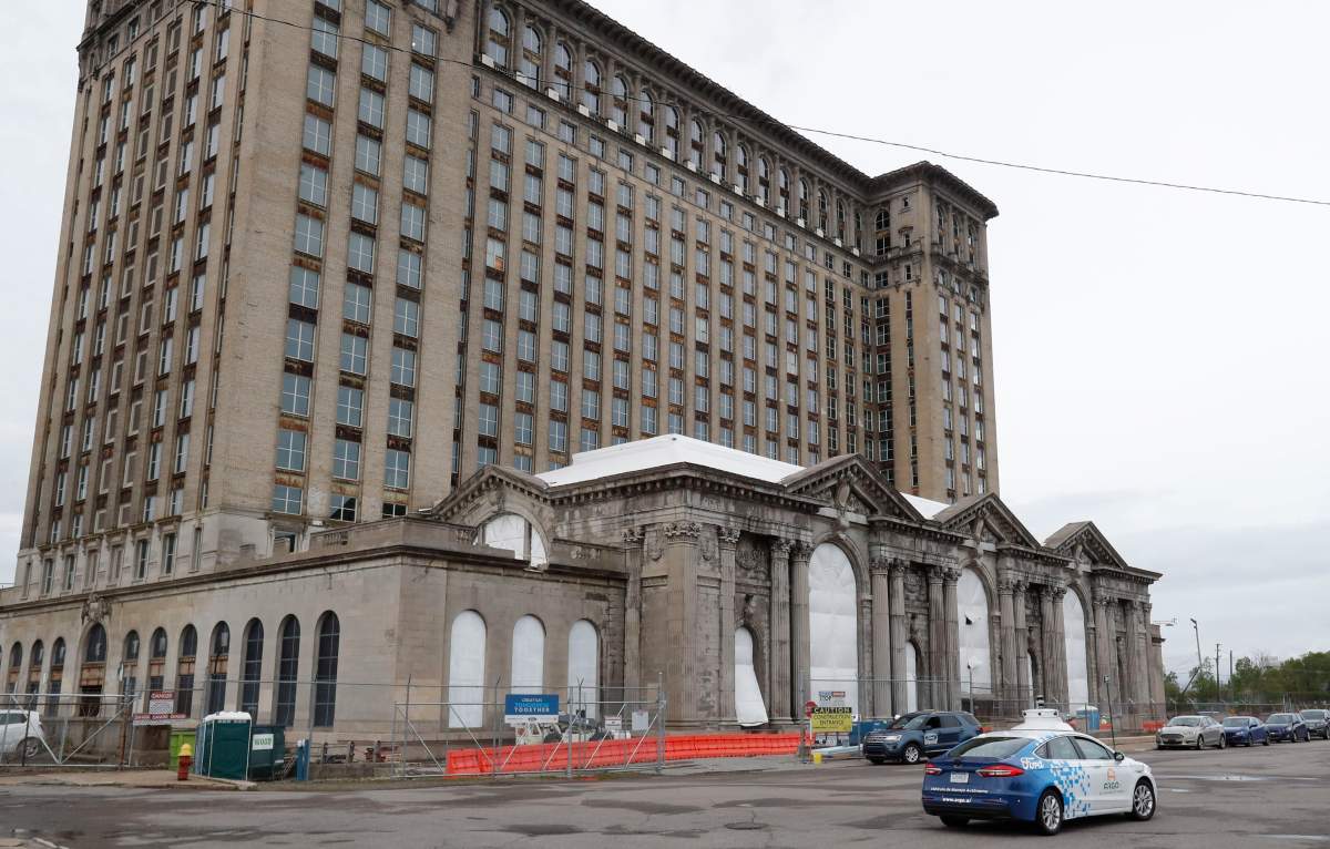 FILE - A Ford autonomous car drives by the Michigan Central train depot, Thursday, May 23, 2019, in Detroit.