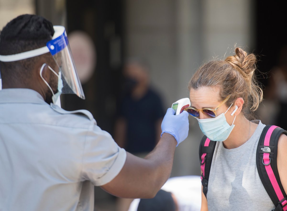 A woman has her temperature prior to entering a store in Montreal, Saturday, Aug. 1, 2020.