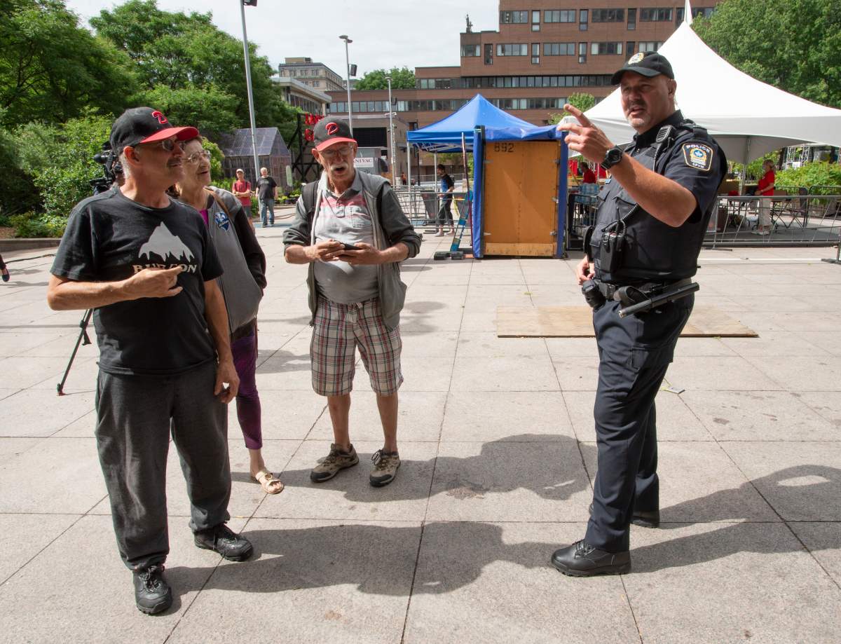 FILE: Const. Raphael Bergeron speaks with citizens as Montreal police launch a pilot project to help the vulnerable, Tuesday, July 21, 2020 in Montreal. 