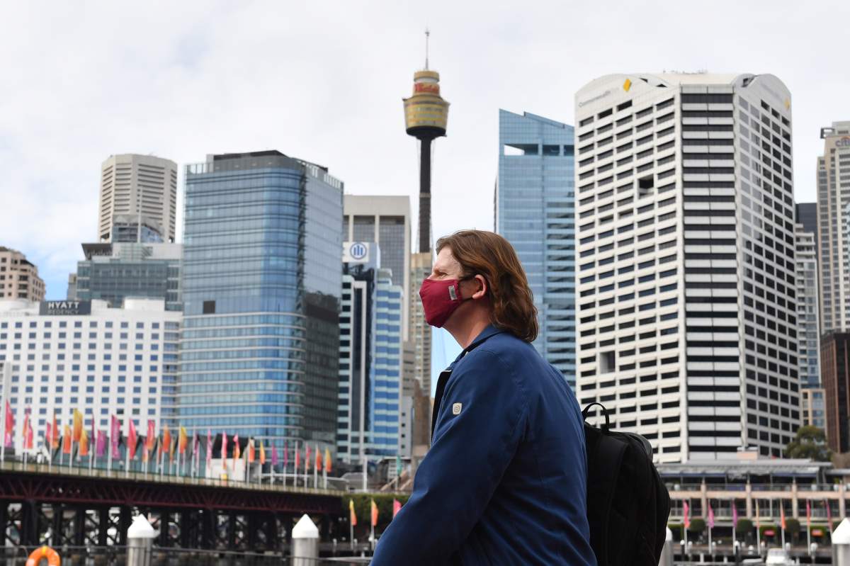 epa08583077 A pedestrian wearing a face mask at Darling Harbour in Sydney, New South Wales (NSW), Australia, 04 August 2020. NSW Premier Gladys Berejiklian said it was 'strongly recommended' that people wear masks from Monday in enclosed spaces (such as public transport), if they work in a customer-facing role (such as hospitality or retail), if they attend a place of worship, or if they are in an area where there is high community transmission.