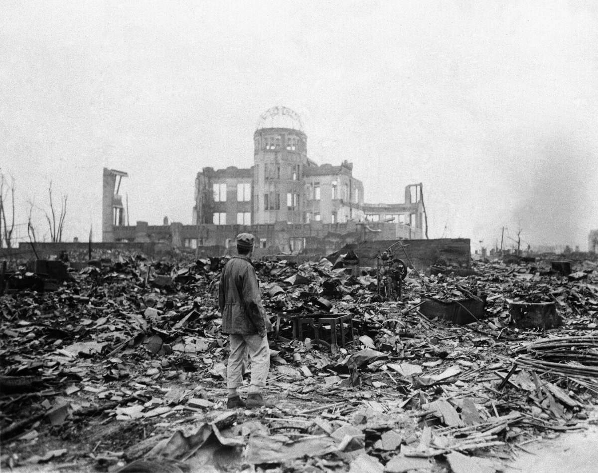 FILE – In this Sept. 8, 1945, file photo, an allied correspondent stands in a sea of rubble before the shell of a building that once was a movie theater in Hiroshima, western Japan, a month after the first atomic bomb ever used in warfare was dropped by the U.S. to hasten Japan’s surrender. Many people exposed to radiation developed symptoms such as vomiting and hair loss. Most of those with severe radiation symptoms died within three to six weeks. Others who lived beyond that developed health problems related to burns and radiation-induced cancers and other illnesses.