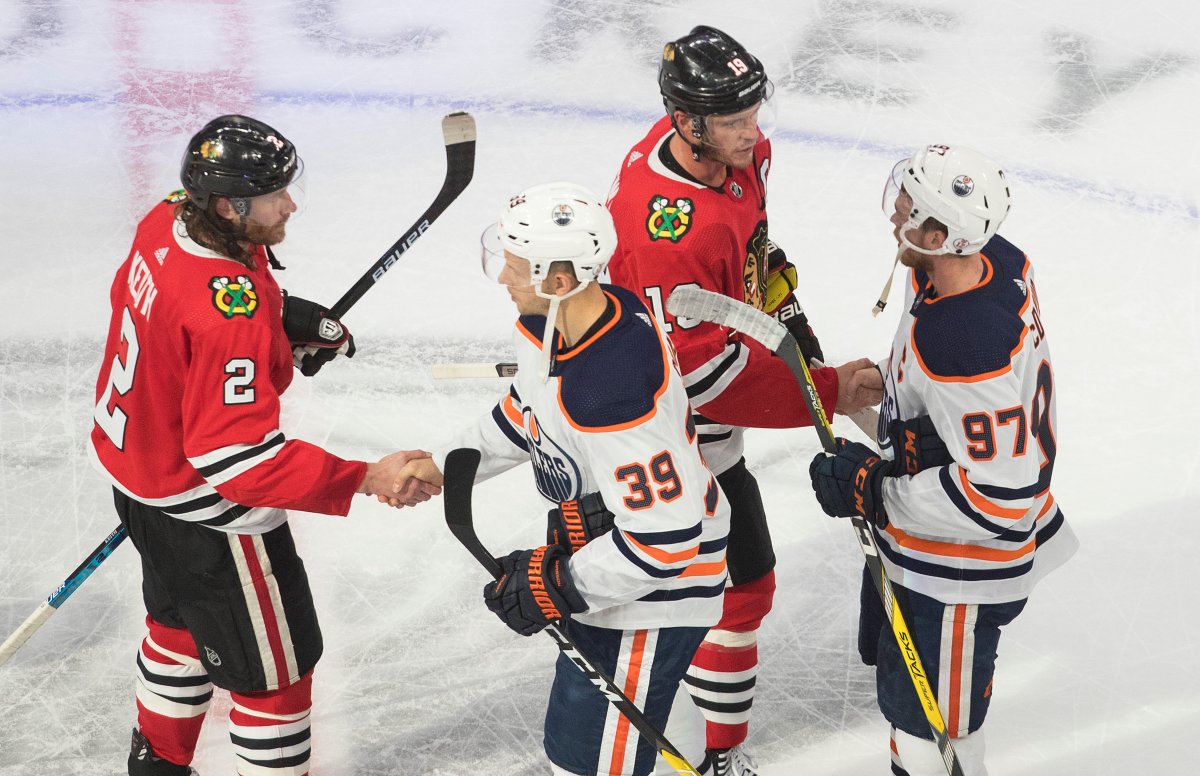 Edmonton Oilers' Alex Chiasson (39) and Connor McDavid (97) shake hands with Chicago Blackhawks' Duncan Keith (2) and Jonathan Toews (19) following NHL qualifying round game action in Edmonton, on Friday August 7, 2020. THE CANADIAN PRESS/Jason Franson.